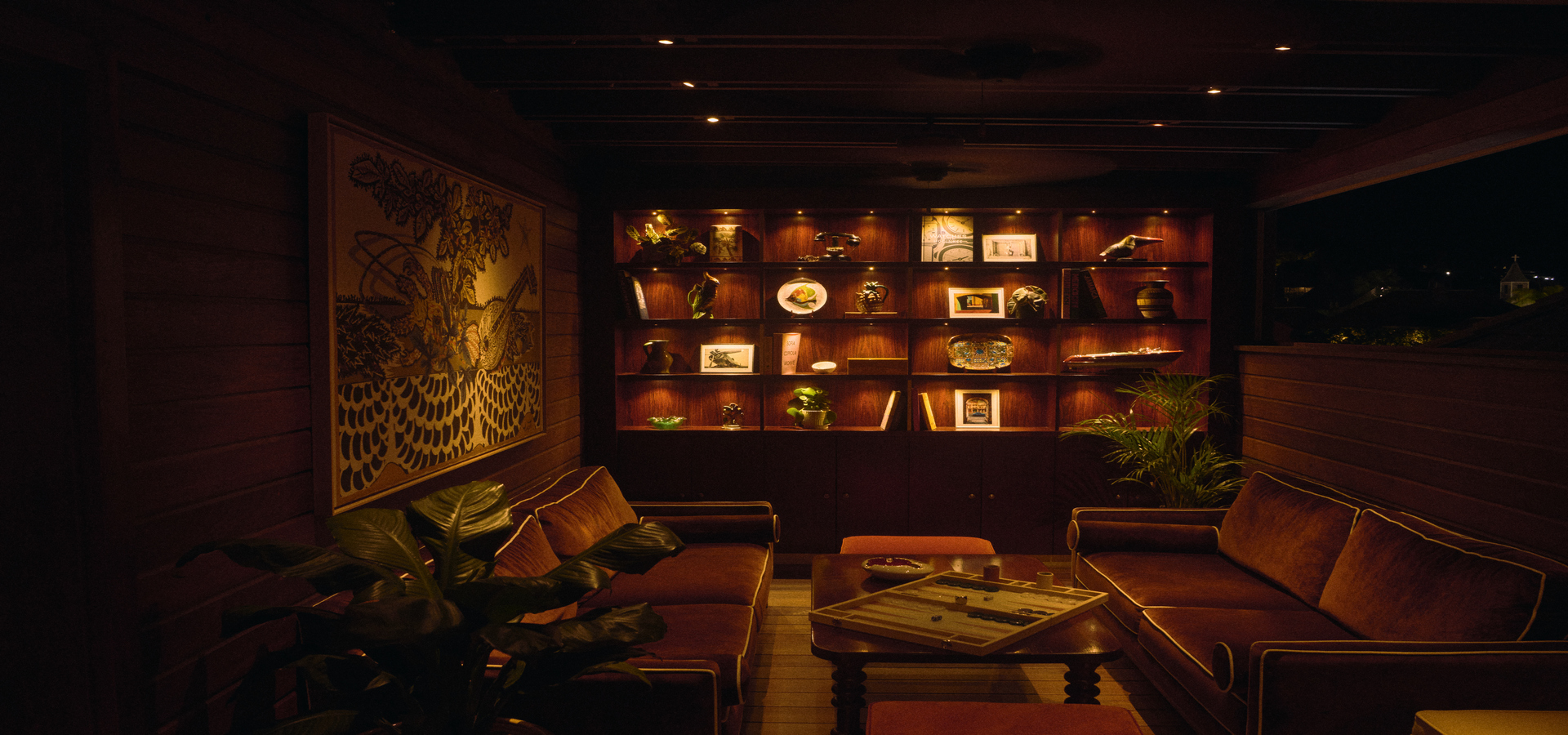 Espace détente du restaurant Pampelonne, terrasse en bois, oliviers et planches de surf